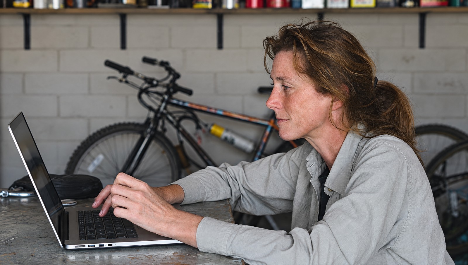 Photographic illustration of a business owner using a laptop at a bicycle shop counter