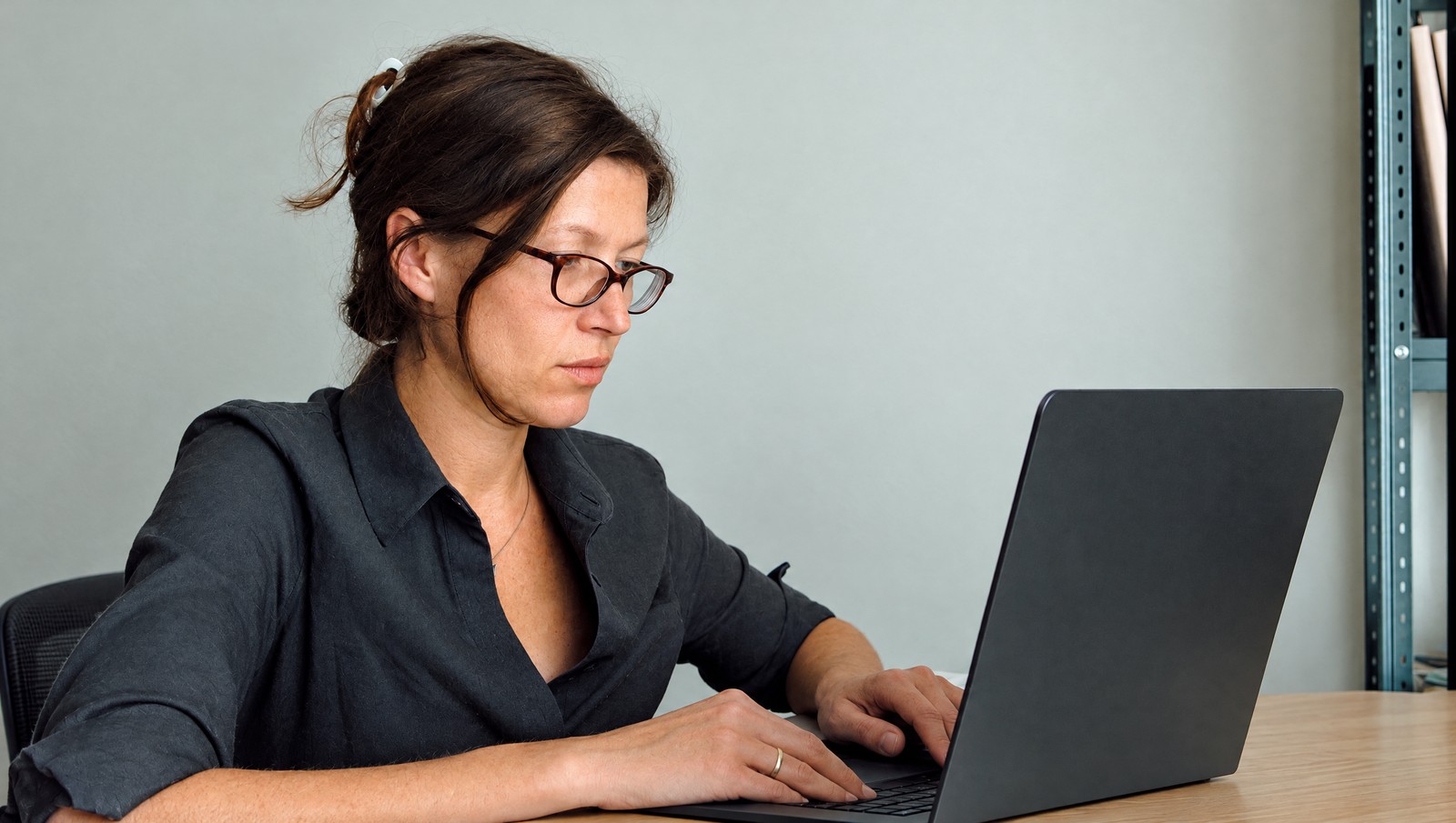 Photographic illustration of a writer concentrating on a laptop in a plain office
